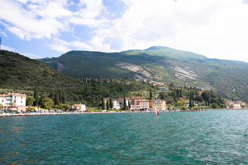Panorama of the gorgeous Lake Garda surrounded by mountains and windsurfer pro-rider surfing in...
