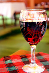 Red wine in wineglass on the table with a tablecloth in a restaurant. loneliness. Alcoholism..