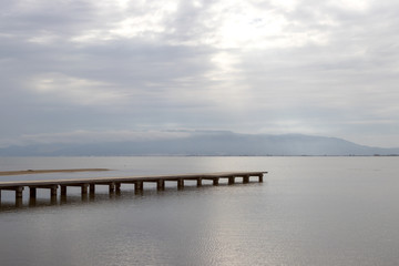 Fototapeta na wymiar wooden bridge on the beach on a cloudy day