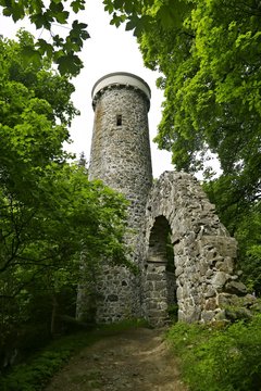 Lookout tower Hamelika, close to Marianske Lazne, Czech Republic, made of stone build by Friedrich Zickler in 1876 standing on hill with elevation 723 metres, surrounded by green trees, vertical image