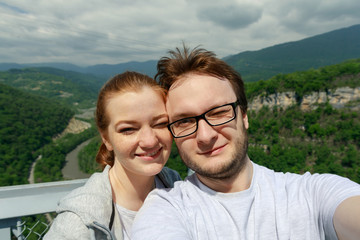 Travelling young couple take the selfie shot, smiling and happy. Summer mountains walk