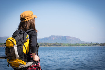 Tourist young woman wearing hat enjoying near the sea.