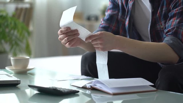 Man revising check for utilities, calculating income and expenses, family budget