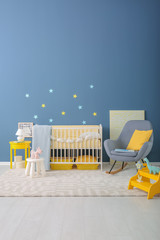 Baby room interior with crib and rocking chair near wall