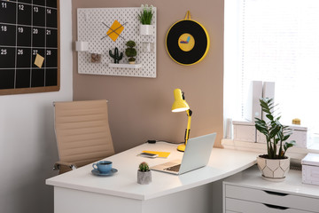 Stylish workplace interior with laptop on table
