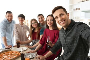 Happy friends taking selfie indoors