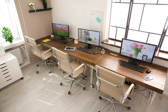 Stylish workplace interior with computers on tables