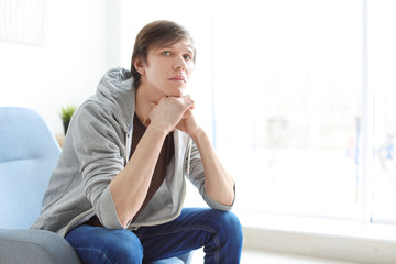 Portrait of confident young man in armchair