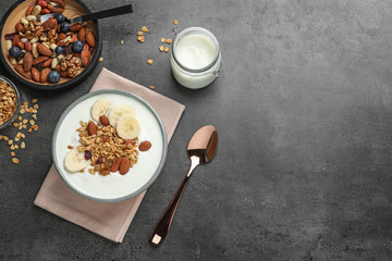 Tasty yogurt with banana and granola for breakfast on table, top view