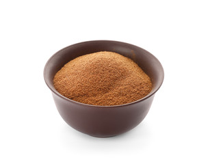 Bowl with aromatic cinnamon powder on white background