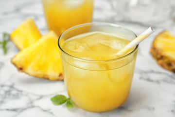 Glass with delicious pineapple juice on table