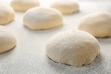 Fototapeta na wymiar Fresh raw dough with flour on table