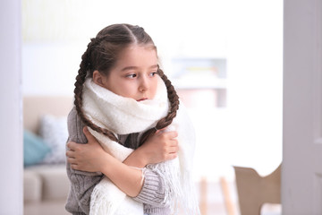 Sad little girl suffering from cold on blurred background