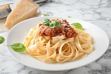 Plate with delicious pasta bolognese on table