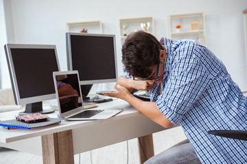 Businessman sitting in front of many screens