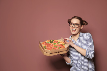 Attractive young woman with delicious pizza on color background