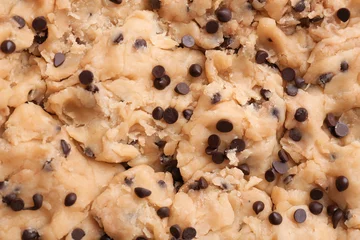 Fototapeten Cookie dough with chocolate chips as background, closeup © New Africa