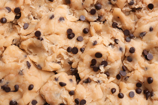 Cookie dough with chocolate chips as background, closeup