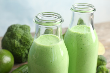 Bottles with healthy detox smoothie on table, closeup