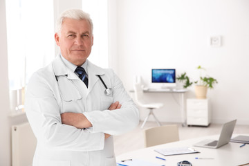Portrait of male doctor in coat at workplace in clinic. Cardiology center