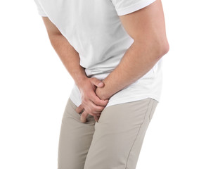 Young man with urological problems suffering from pain on white background