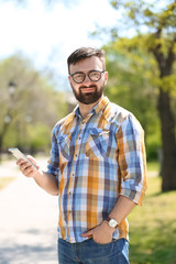 Portrait of young man with smartphone outdoors