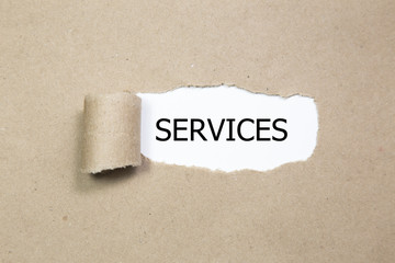 The word services appearing behind torn paper