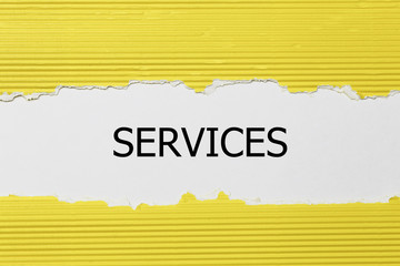 The word services appearing behind torn paper