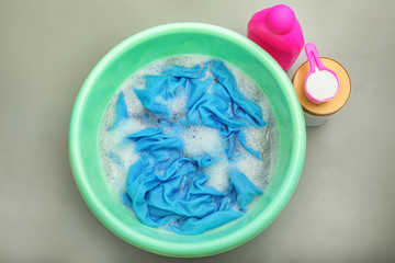 Color clothes with foam in basin, top view