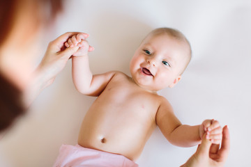 Baby massage. Mother massaging and doing gymnastic with arms of her kid