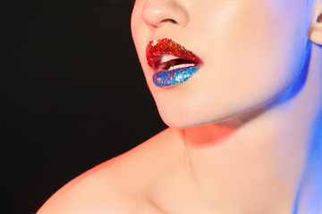 Fototapeta premium Beautiful young model with creative lips makeup on black background