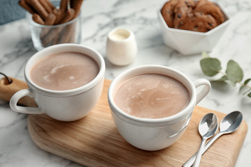 Tasses avec boisson chaude au cacao sur table