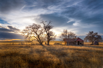 Old farmhouse at sunset in the countryside