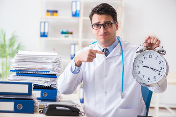 Doctor with alarm clock in urgent check-up concept
