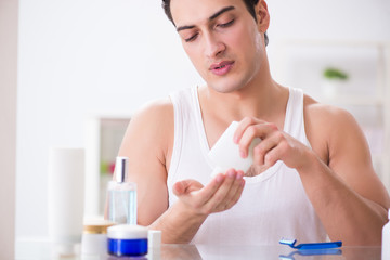 Young handsome man shaving early in the morning at home