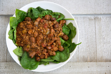 hot and spicy chili on spinach greens