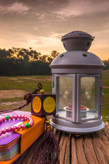 Quran, beads, and lantern on old wood with a beautiful sunrise as background. Ramadhan Concept.