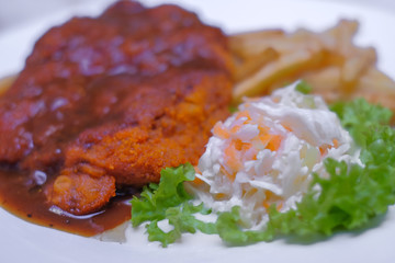 Chicken chop with vegetable and black pepper sauce in plate over dining table