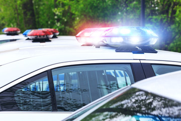 Some police cars with focus on siren lights. Beautiful siren lights activated on a police car before leaving the department park. Police cars stationed side by side, in full operation. © vmargineanu