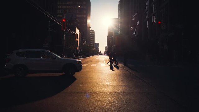 City Buss and People Crossing Busy Downtown Street with Background Traffic During Golden Hour