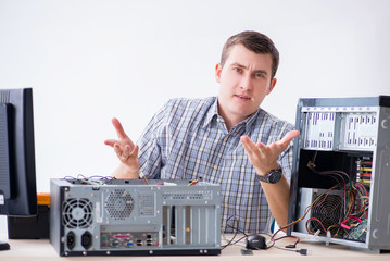 Young technician repairing computer in workshop