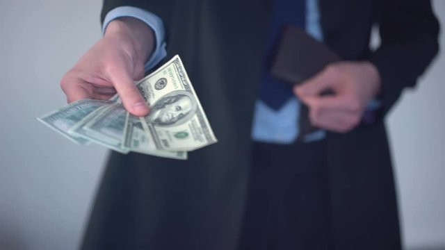 Man giving bundle of dollars, purchase in shop, payment of penalty, kickback