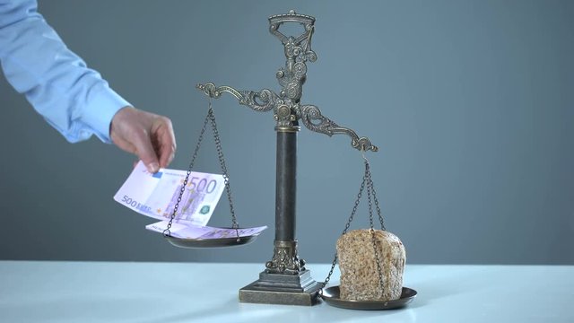 Bread outweighs euro on scales, poverty concept, poor people more than rich