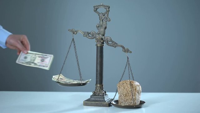 Bread outweighs dollars on scales, poverty concept, rising prices for essentials