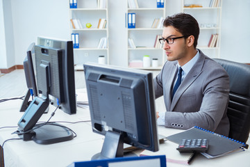 Fototapeta premium Businessman sitting in front of many screens