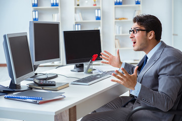 Businessman sitting in front of many screens