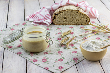 Rye leaven on a glass jar with rye flour, cob and bread