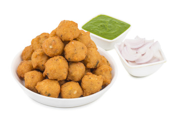 Indian Spicy Street Food Dal Vada Also Know as Moong Dal Vada, Pakoda, Pakode, Pakore, Moong Vada, Pakora or Bhajiya Served with Green Chutney or Onion isolated on White Background