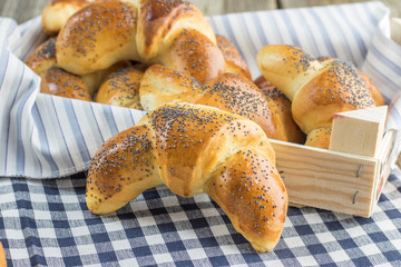 Poppy seed croissant on white-blue clothtable