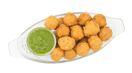 Indian Spicy Street Food Dal Vada Also Know as Moong Dal Vada, Pakoda, Pakode, Pakore, Moong Vada, Pakora or Bhajiya Served with Green Chutney or Onion isolated on White Background